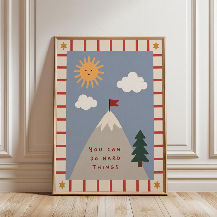 The image is a framed poster with a mountain, clouds, a flag, and a tree, along with the text "You can do hard things" written on it.
