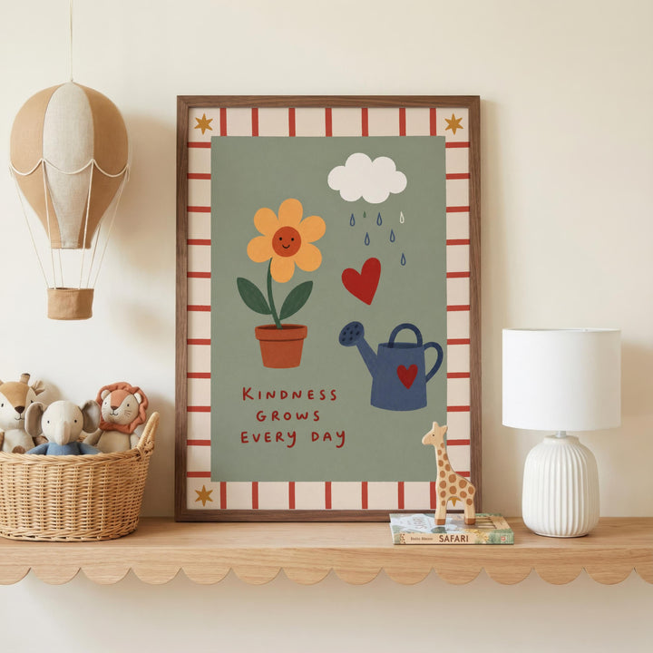 a framed poster with a colorful illustration of a flower, a watering can, and a heart, along with the text "Kindness grows every day". The poster is displayed on a shelf, accompanied by a basket of stuffed animals, a lamp, and a small toy giraffe.