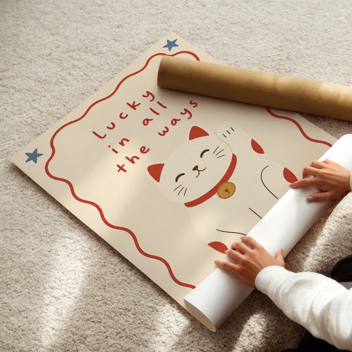 A person's hands are rolling up a poster with a cat illustration and the text "Lucky in all the ways" on it.