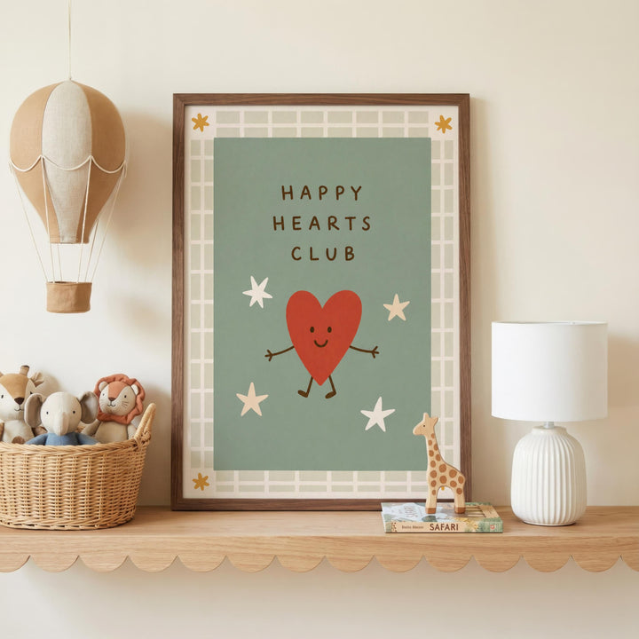a framed poster with a heart and stars design, a hot air balloon, a basket of stuffed animals, a lamp, and a shelf with books.