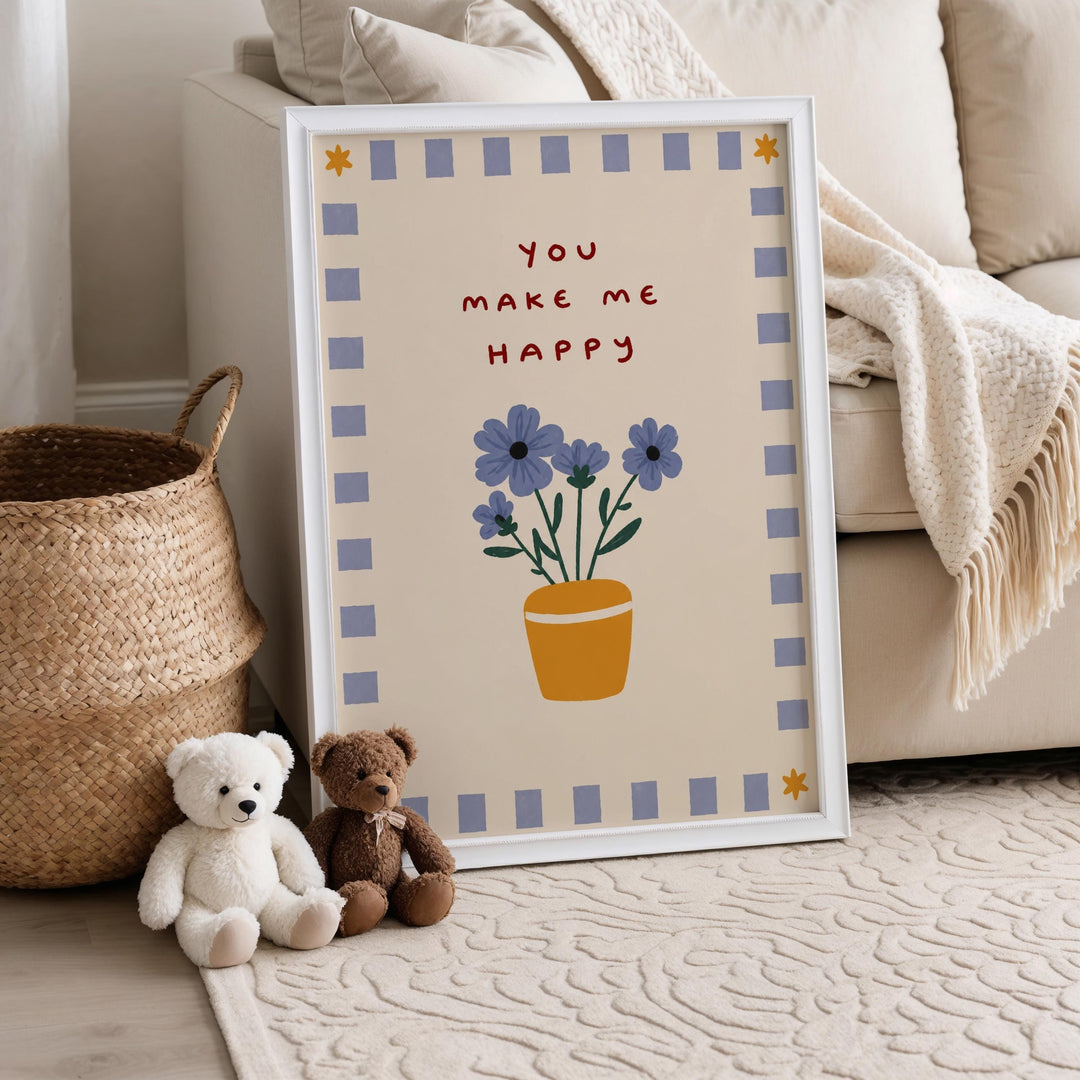 A framed poster with a floral design and the text "You make me happy" is displayed on a wall, accompanied by two teddy bears sitting on the floor next to it.