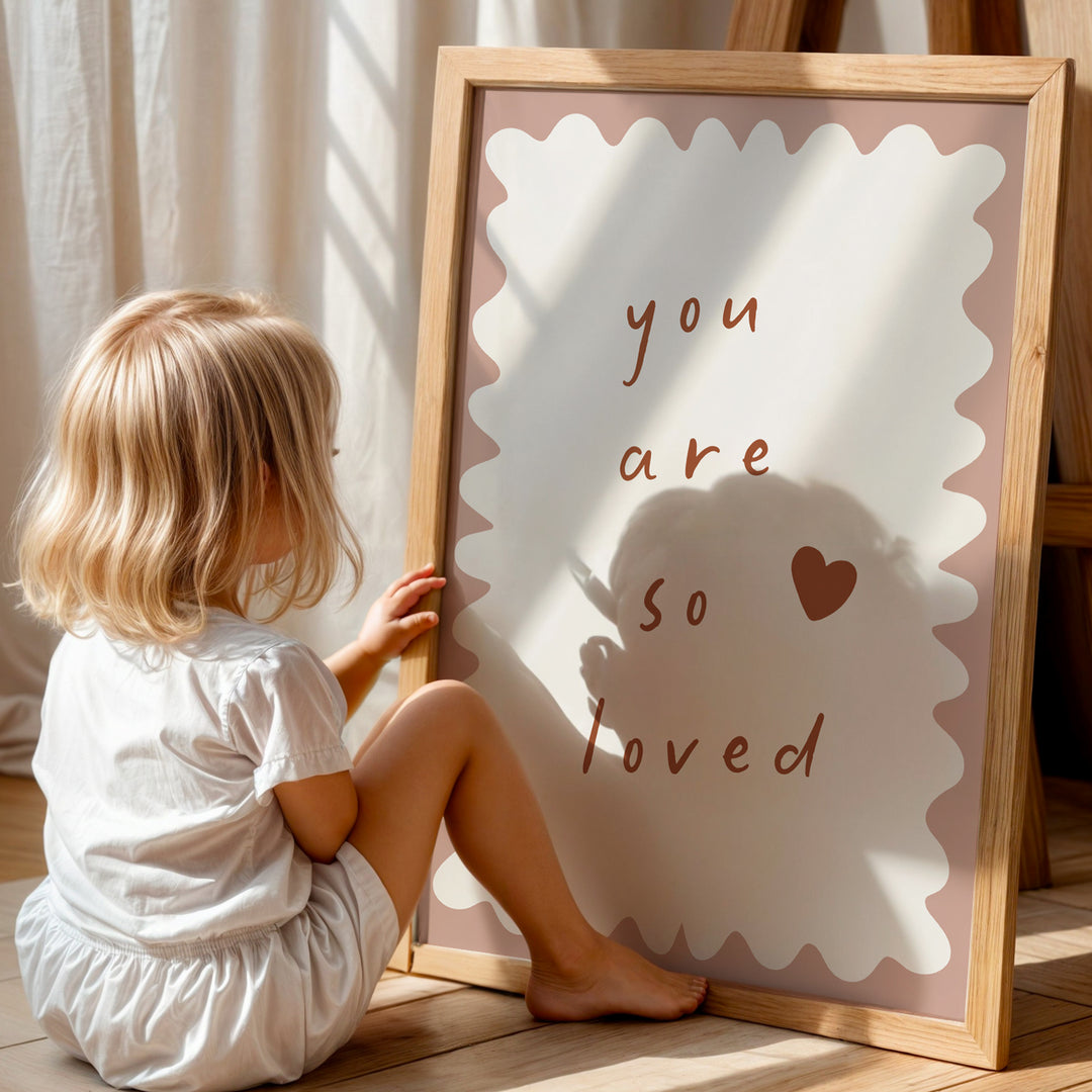 a little girl sitting on the floor next to a sign