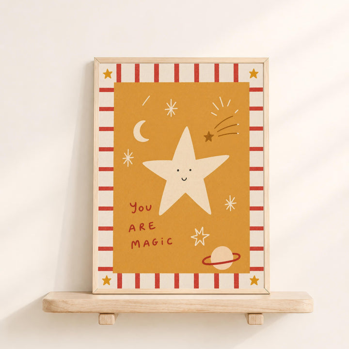 A framed illustration of a star with a smiling face, surrounded by celestial elements such as a crescent moon, stars, and a planet. The text "You are magic" is written below the star.