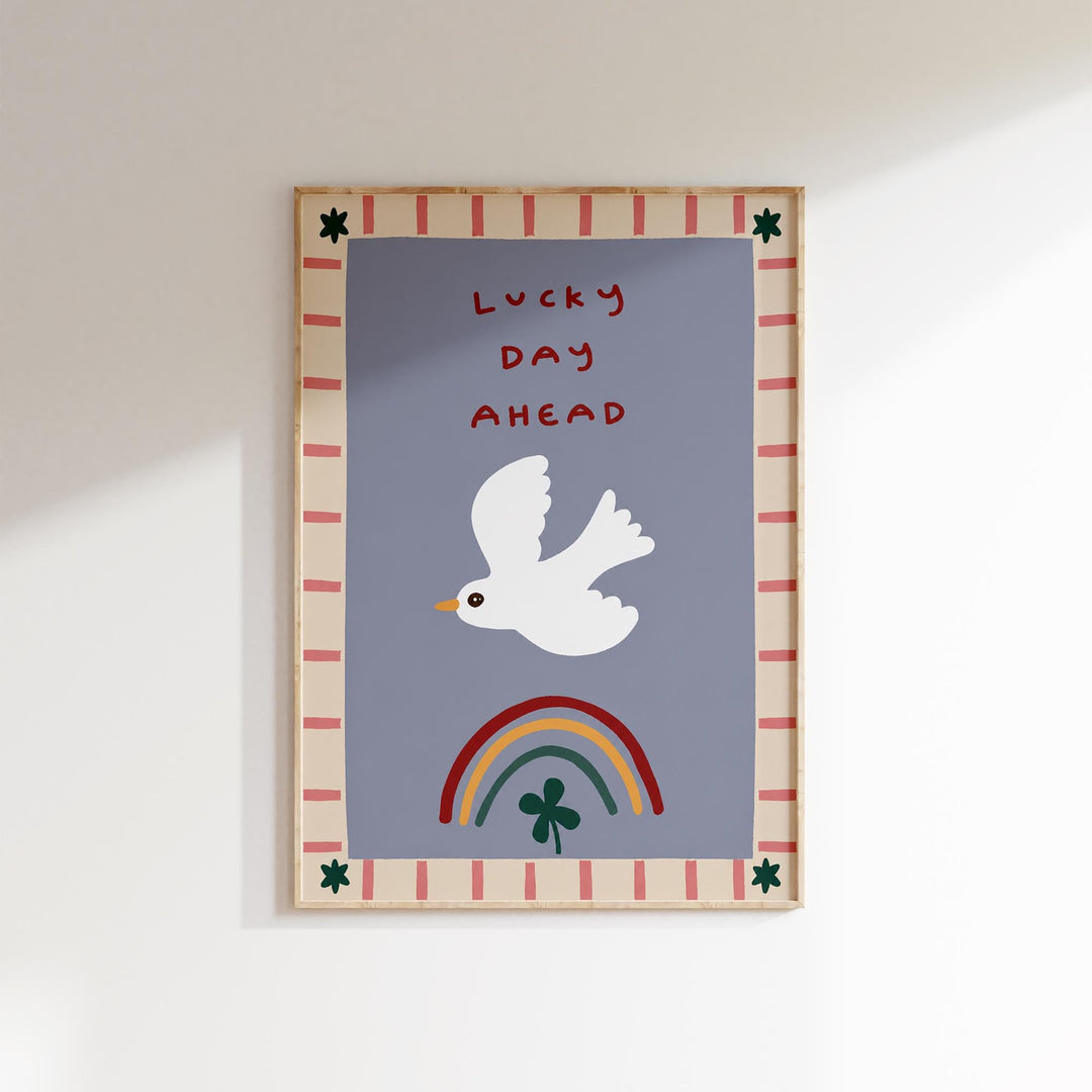 The image is a framed poster with a white bird, a rainbow, and a clover. The text on the poster says "Lucky Day Ahead".