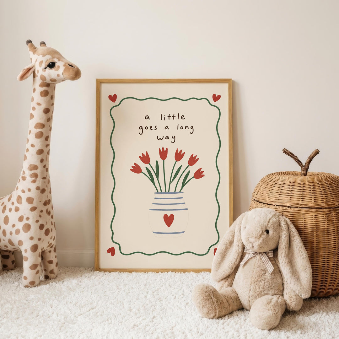 A framed picture with a giraffe and a stuffed rabbit is displayed on a white carpet, accompanied by a wicker basket and a stuffed bunny.