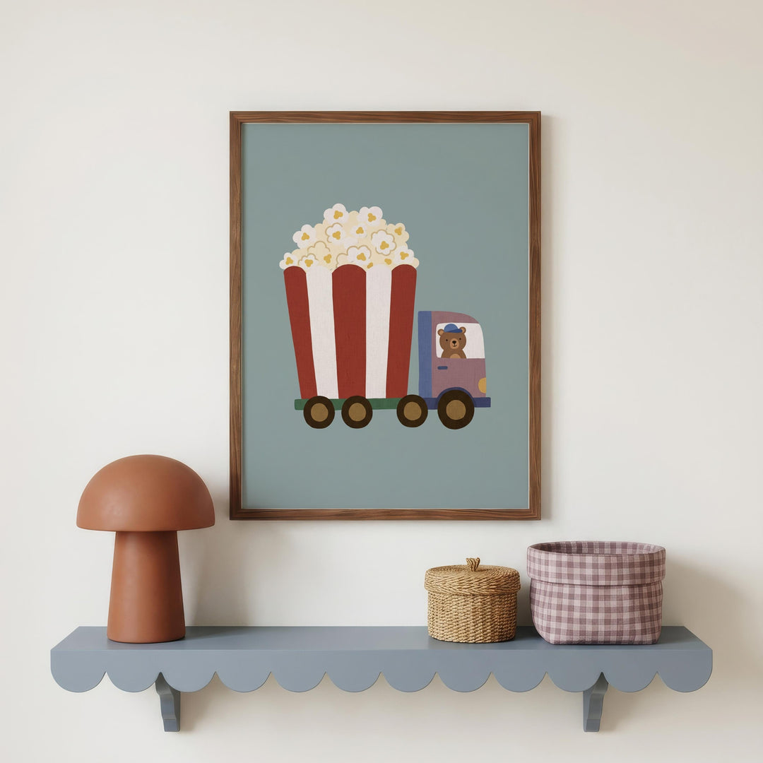 a framed illustration of a red and white striped truck with a cartoon character inside, placed on a shelf below a lamp and a woven basket.