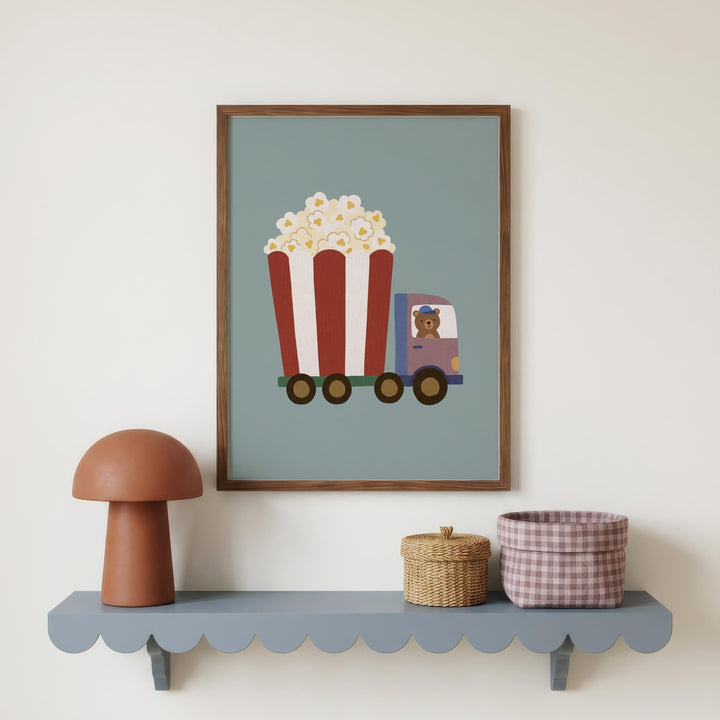 a framed illustration of a red and white striped truck with a cartoon character inside, placed on a shelf below a lamp and a woven basket.