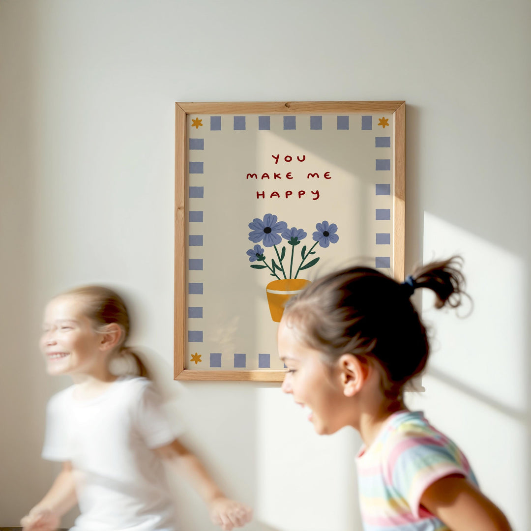 Two young girls are running in front of a framed poster with a floral design and the text "You make me happy".