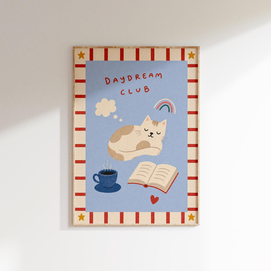The image is a framed poster with a cat, a cup of coffee, and an open book, all set against a blue background with a red and white striped border.